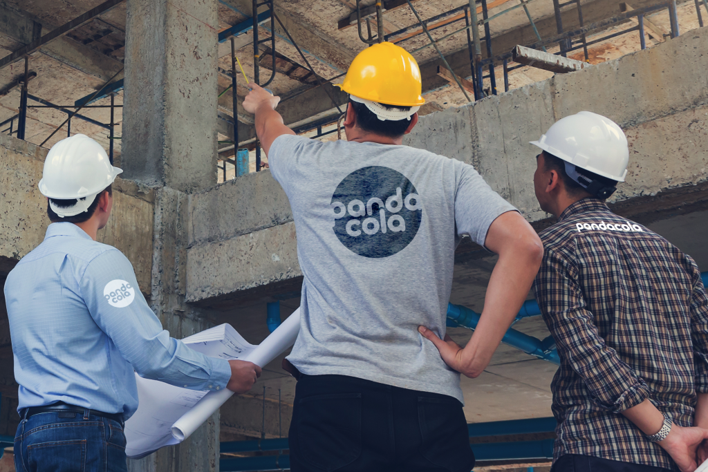 Trois personnes sur un chantier avec des vêtements professionnels personnalisés Pandacola